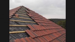 image of tile roofing being installed